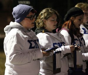 First-year Jake Phillips, a pledge for the Sigma Kappa Tau, stands in the Brodahl parking lot reciting songs from the pledgebook alongside other sorority pledges. Photo by Linnea Ritchie.