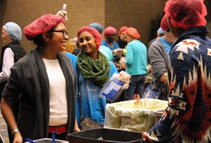 Augustana students and members of the Quad Cities community volunteer to package food for Syrian refugees at the Waterfront Convention Center in Bettendorf on Dec. 5. Photo by Marlen Gomez.