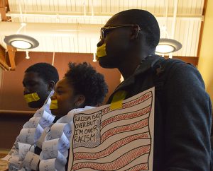 (Left to right) Sophomores Denzel Woodall, Kamille Brashear, Gbadebo Balogun stand during the protest on Dec. 15. Photo by Ryan Silvola.