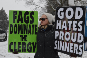 A member of the Westboro Baptist Church protests outside of Sacred Heart Cathedral Parish in Davenport on Sunday, Photo by Alex Cintado.